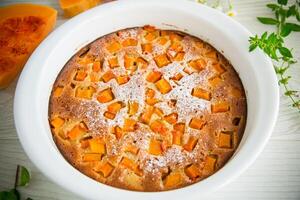 sweet pumpkin pie with pumpkin slices in a ceramic mold photo