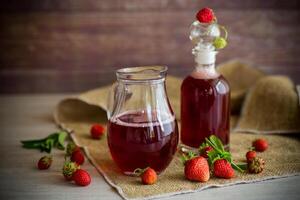 dulce cocido fresa jarabe en un vaso licorera foto