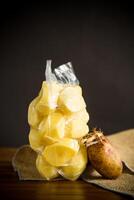 peeled potatoes closed in a vacuum bag and old sprouted potatoes photo