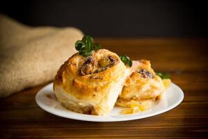 Sweet curled bun with jam, raisins in powdered sugar photo