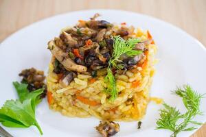 Diet pilaf with mushrooms and vegetables in a plate . photo