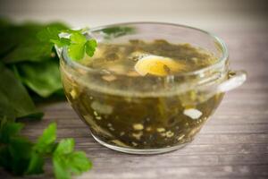 Spring soup from fresh sorrel with boiled eggs in a plate photo