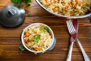 Braised cabbage with carrots, onions and herbs in a ceramic bowl photo