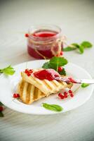 fried bread croutons for breakfast with redcurrant jam in a plate with berries photo