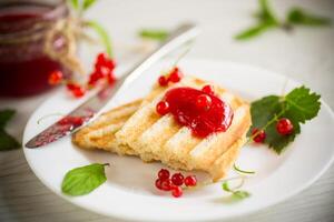 fried bread croutons for breakfast with redcurrant jam in a plate with berries photo