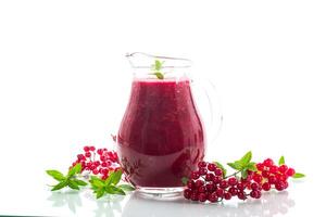 recién exprimido grueso natural jugo con pulpa desde maduro rojo viburnum en un licorera foto