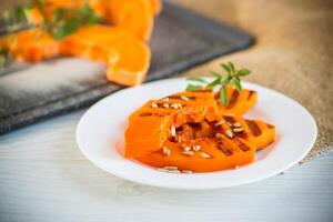 sweet baked grilled pumpkin with seeds in a plate photo