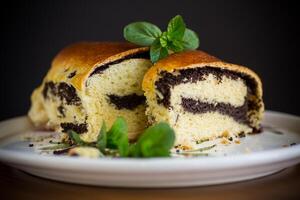 roll with poppy seeds inside on a wooden table. photo