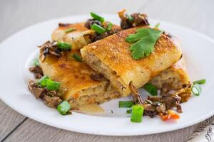 fried thin pancakes stuffed with meat and mushrooms. photo