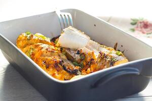 fish baked with spices and vegetables in the oven. photo