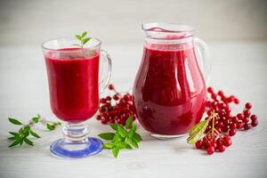 freshly squeezed thick natural juice with pulp from ripe red viburnum in a decanter photo