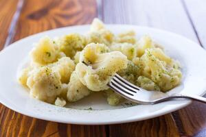 Cooked cauliflower, steamed, in a plate with spices . photo