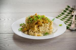 cooked bulgur with meat sauce and vegetables in a plate photo