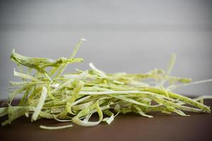 Homemade noodles green with greens on a wooden table photo