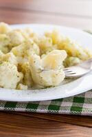 Cooked cauliflower, steamed, in a plate with spices . photo