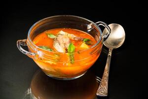 vegetable tomato soup with fish in a plate photo