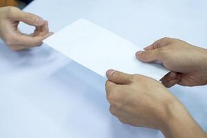 Hand businessman giving blank white envelope photo