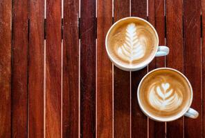 Two coffee cup leaf and heart shaped on wood table photo