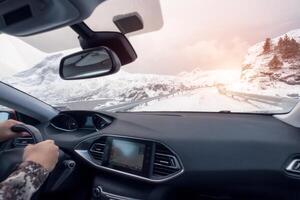 mano participación direccion rueda en lujo privado auto, conducción en rural la carretera en invierno foto