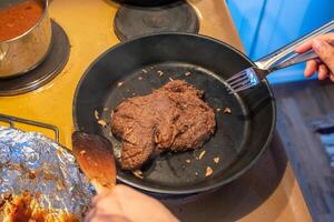 Chef frying beef steak with garlic on skillet photo