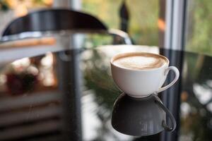 Coffee cup reflection on glass table photo