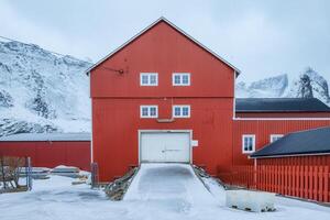 Large red warehouse and mountain on background in winter photo