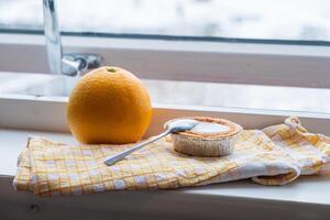 Local dessert on napery with orange on beside window in winter photo