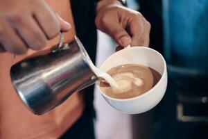 barista torrencial Leche en café taza haciendo corazón foto