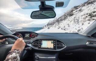 mano participación direccion rueda en lujo privado auto, conducción en rural la carretera en invierno foto