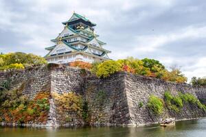 Osaka Castle architecture landmark in autumn garden on lake photo