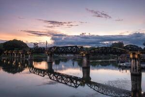 Ancient bridge on River Kwai history of world war II in evening photo