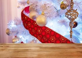 Wooden table top on white christmas tree illumination photo