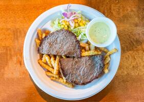 Minced beef grilled sliced with potato, vegetable and sauce on plate photo