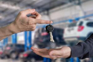 mano entrega terminado coche llaves con dedo y mano recepción en garaje Servicio centrar foto