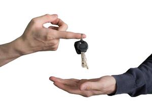 Hand handing over car keys with finger and hand receiving photo
