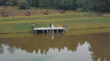 noivo com noiva perto lago dentro a parque. Casamento casal. aéreo tiro video