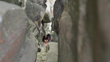 sposo con sposa in piedi nel grotta di montagna colline. nozze coppia nel amore video