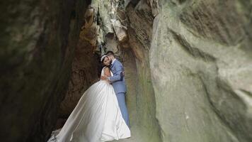 noivo com noiva em pé dentro caverna do montanha colinas. Casamento casal dentro amor video