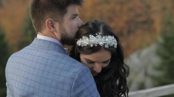 Groom with bride on a mountain hills in the forest. Wedding couple video