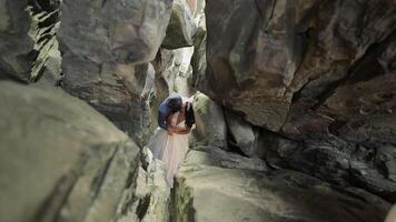 sposo con sposa in piedi nel grotta di montagna colline. nozze coppia nel amore video