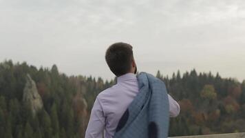 Young man on the hill of a mountain with jacket. Businessman. Bridegroom. Groom video