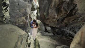 bruidegom met bruid staand in grot van berg heuvels. bruiloft paar in liefde video