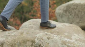 Man feets stepping over boulders mountains near forest. Hill of a high mountain video