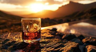 ai generado un vaso de whisky sentado en parte superior de un mesa con un puesta de sol imagen foto