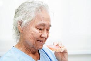 Doctor holding teeth denture in hand for dentist studying about dentistry. photo