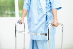 anciana asiática discapacitada paciente camina con andador en el hospital de enfermería, concepto médico. foto