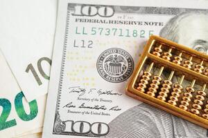 Gold abacus on banknote money, finance trading investment business currency concept. photo