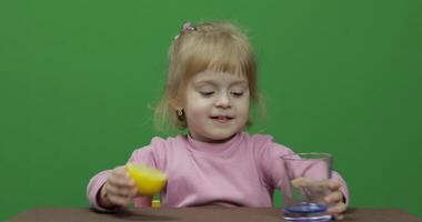 bellissimo giovane ragazza spreme Limone succo con un' smorfia su sua viso video