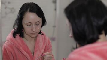 giovane caucasico donna l'applicazione crema maschera su viso. facciale terme procedura a casa video