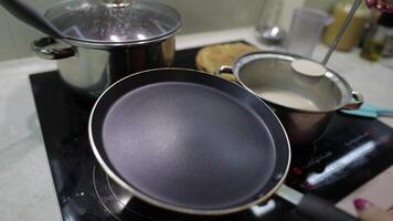 The process of cooking homemade pancakes. Woman pours pancake dough on pan video